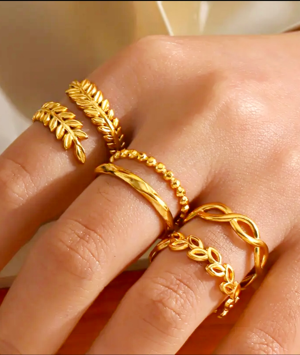 Arayeh gold-tone rings on a warm neutral surface